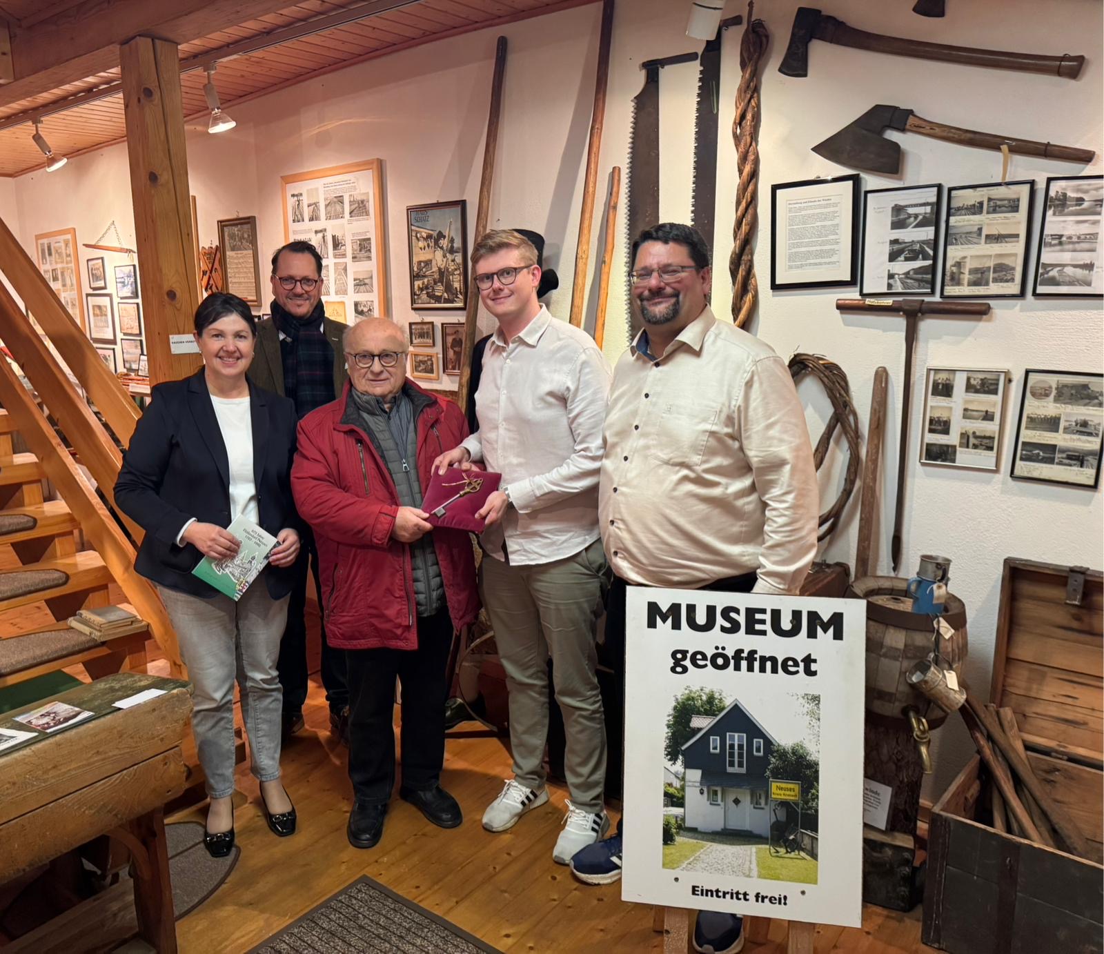 auf dem Bild sind 5 Personen zu sehen und ein Schild Öffnungszeiten des Dorfmuseums Neuss
